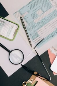 A flat lay of office supplies including a smartphone, document, and pen on a workspace.